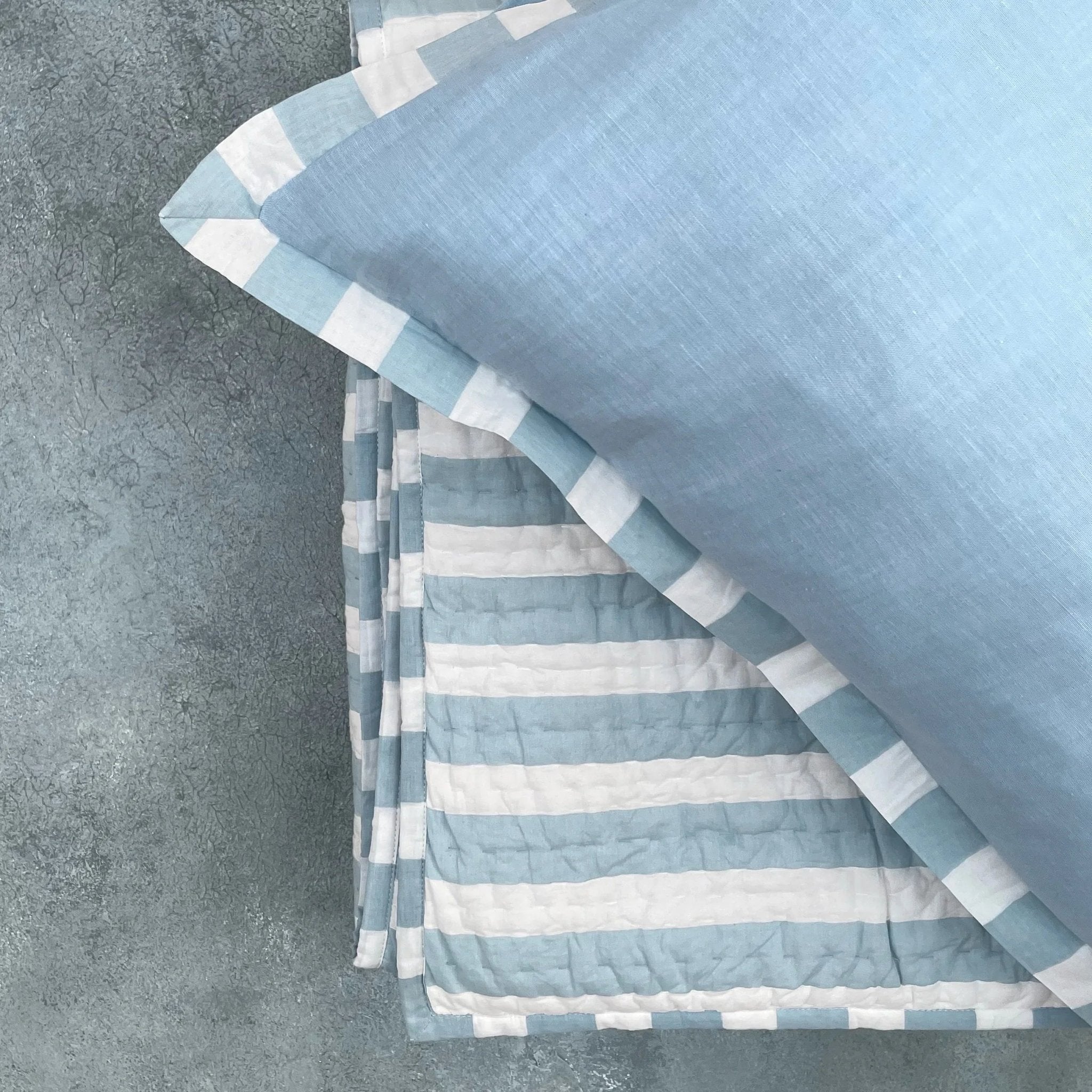 Blue cotton cushion cover with blue and white striped cotton quilt