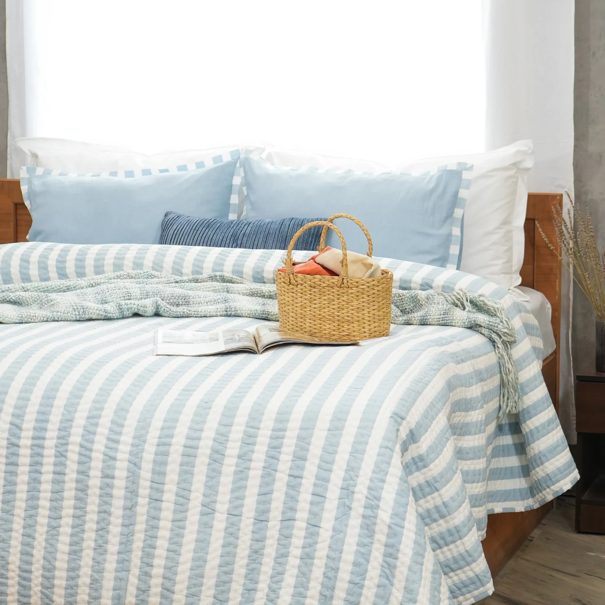 Blue and white striped cotton quilt styled with decorative breakfast tray