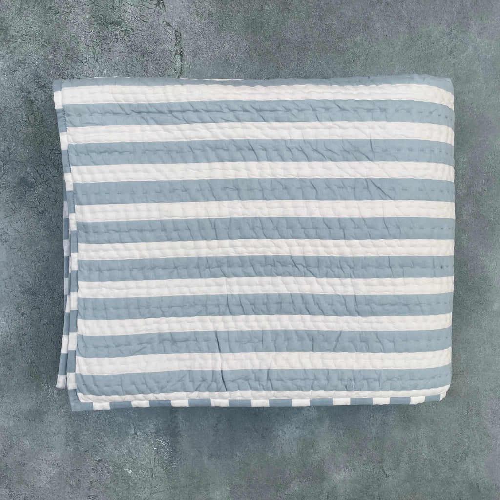 Flat lay of blue and white striped cotton quilt