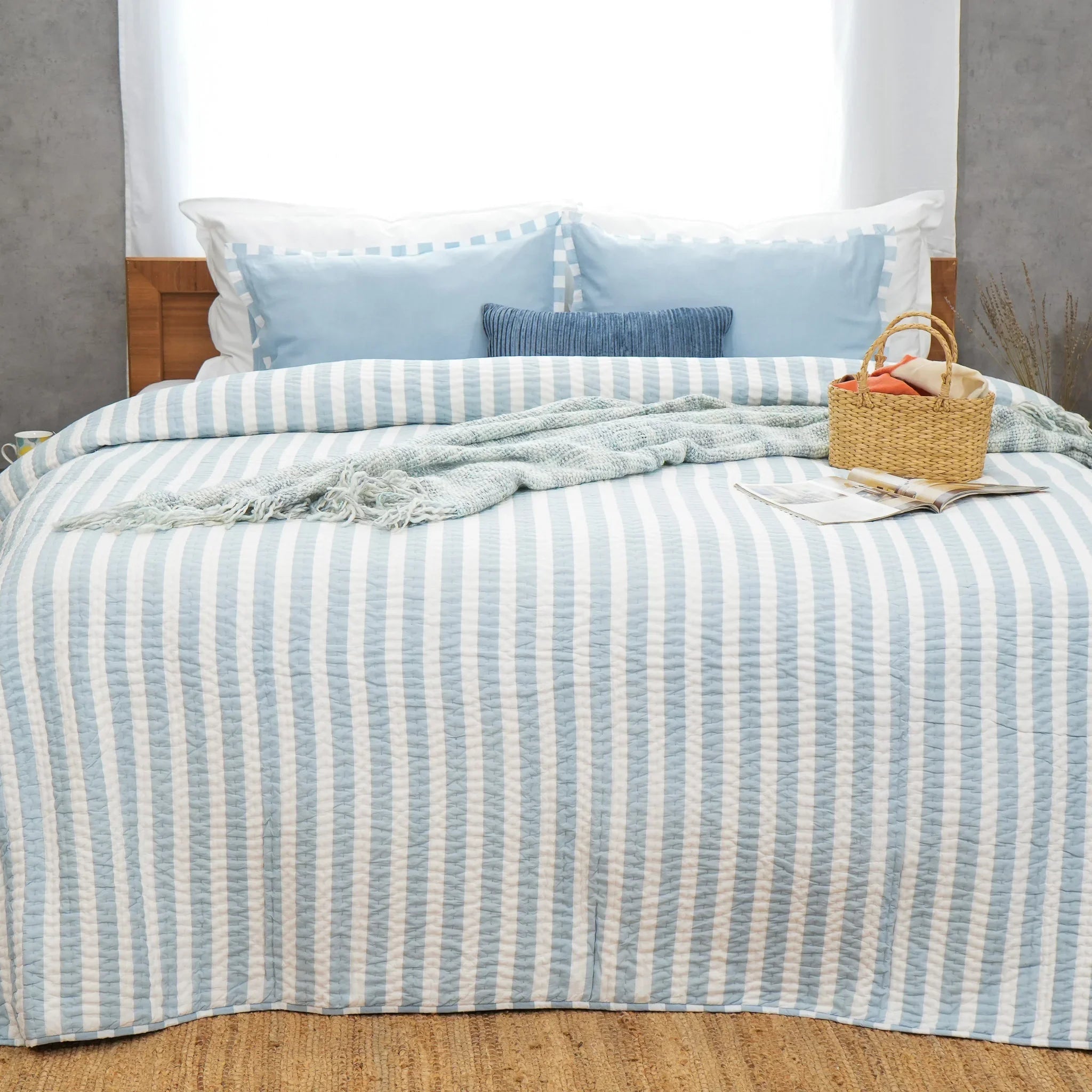 Full bed styled with blue and white striped cotton quilt
