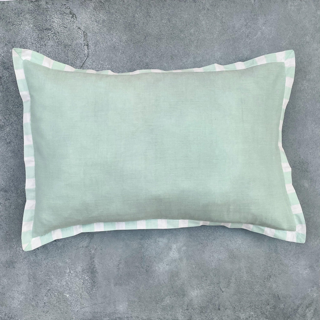 Matching green cotton cushion cover with white piping