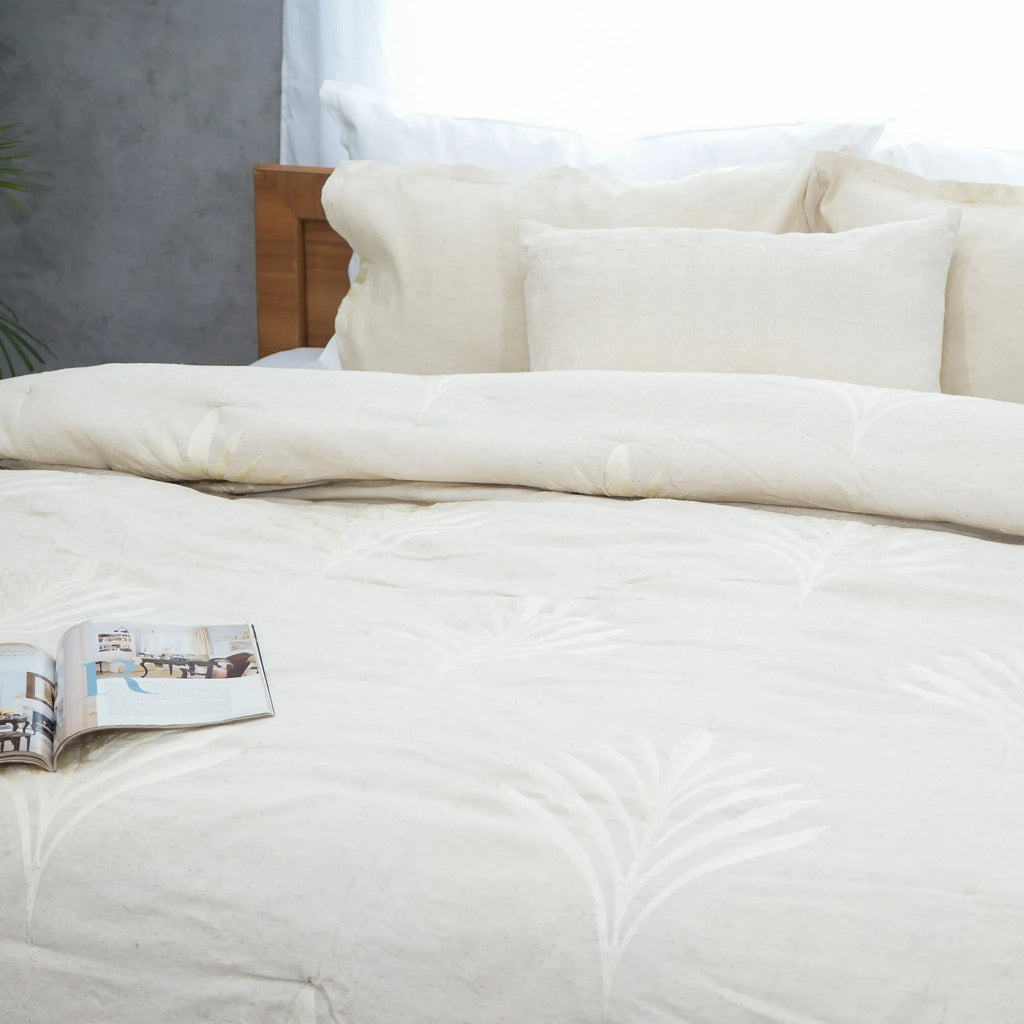 Close-up of natural embroidered cotton-linen quilt on a neatly made bed