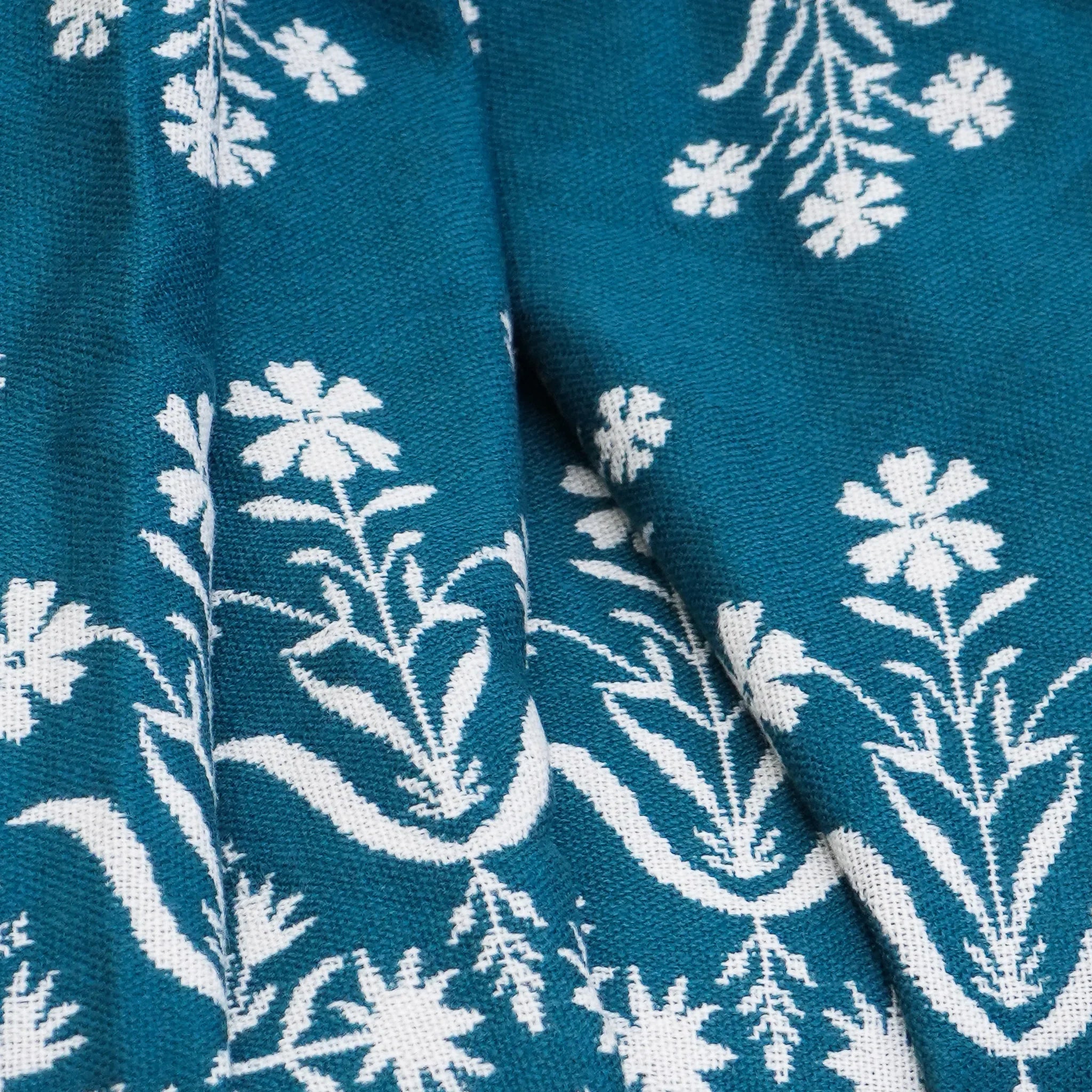 Close-up of blue jacquard floral throw with white floral jacquard design