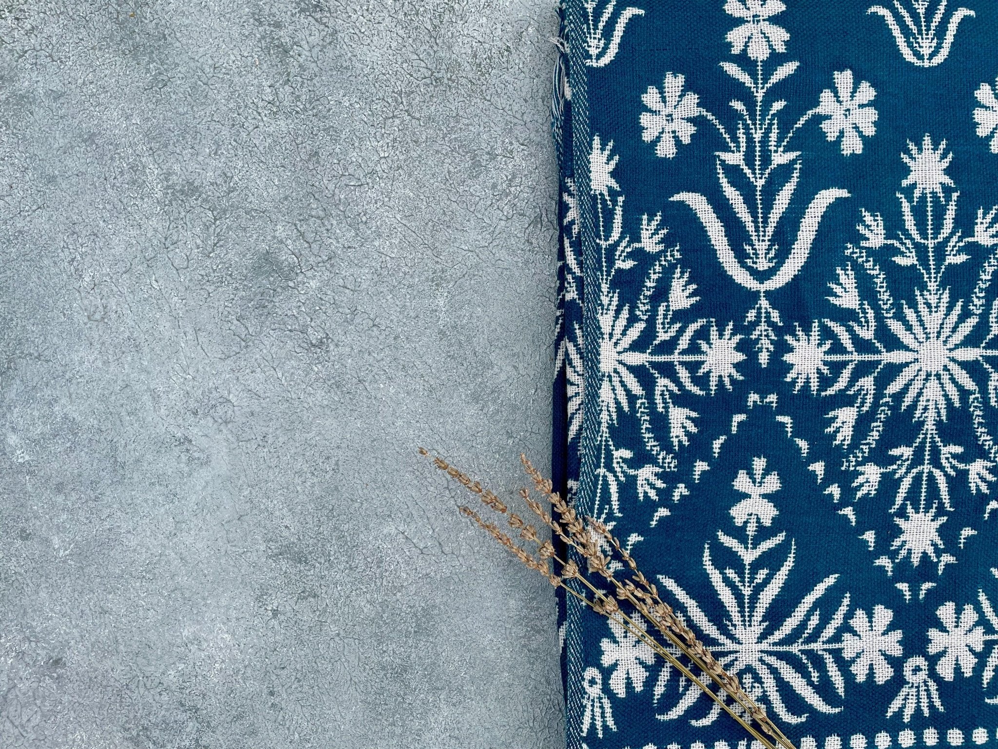 Corner detail of blue jacquard floral throw with woven floral motif