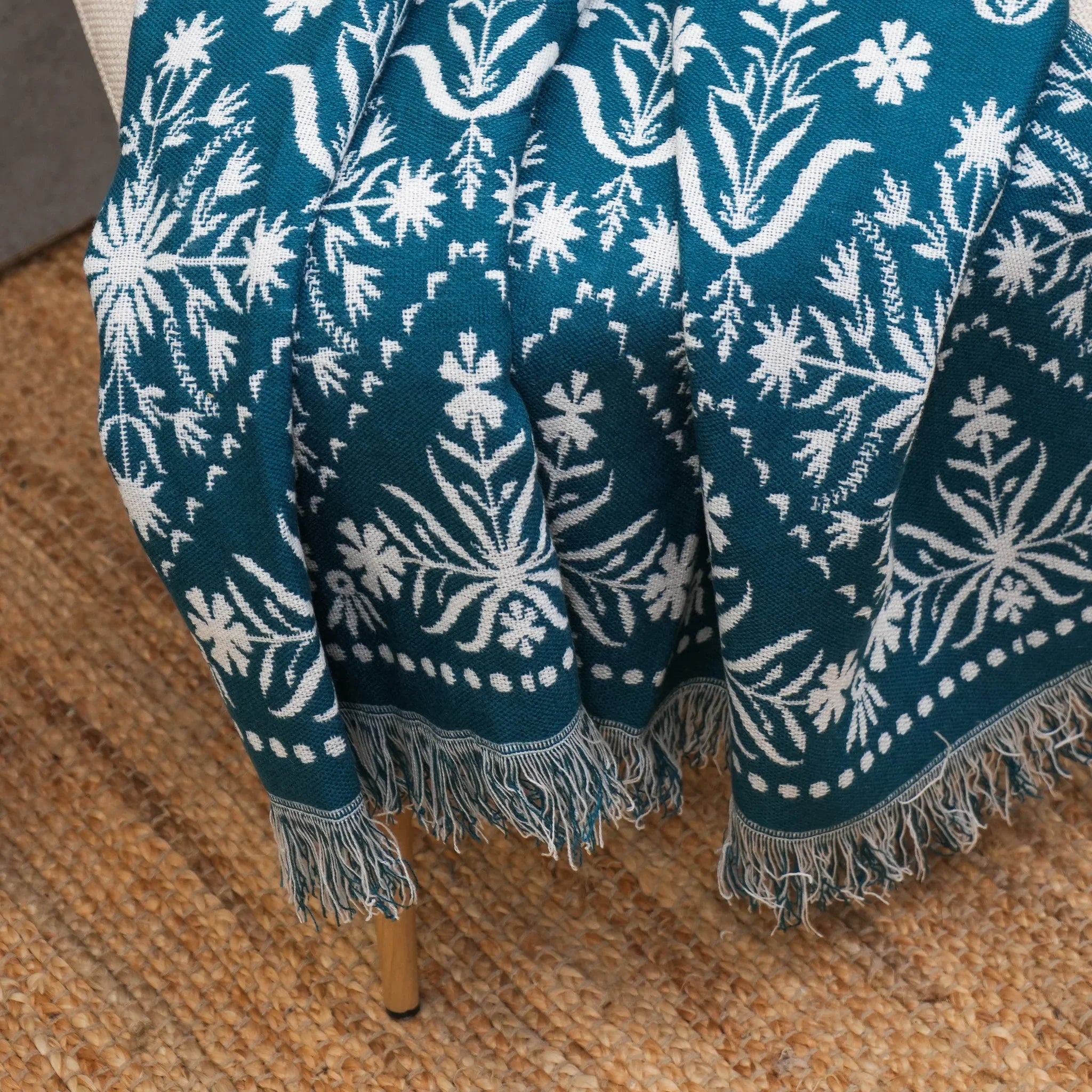 Blue jacquard floral throw showing woven border and fringe detail