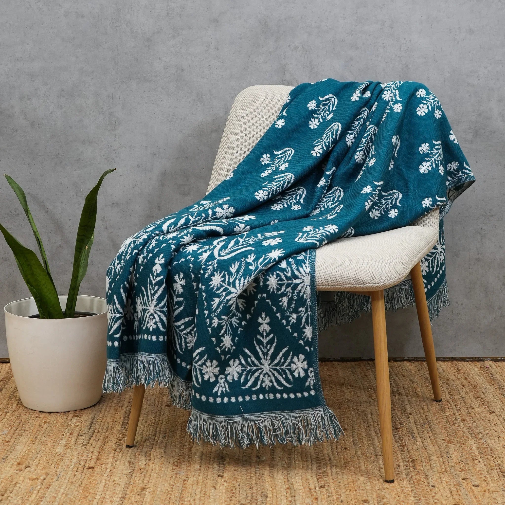 Blue jacquard floral throw draped over a wooden accent chair