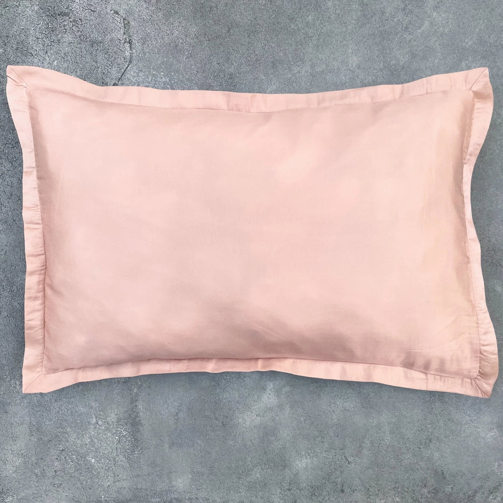 Matching Rose Gold silk cushion cover on grey textured background