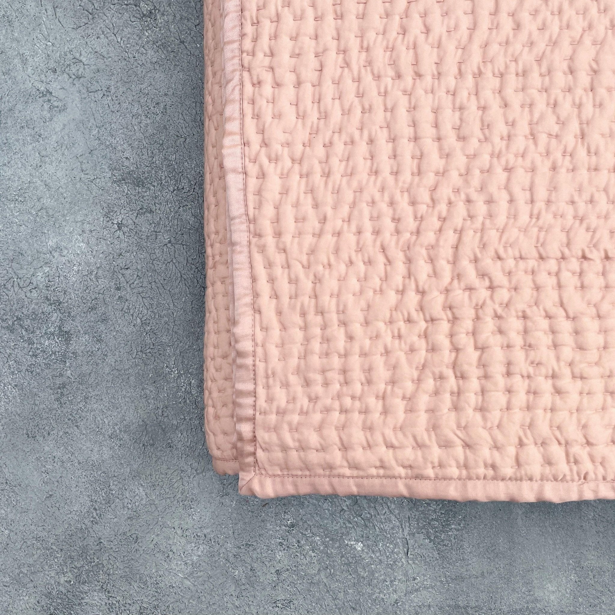 Folded Rose Gold Kantha silk quilt highlighting Kantha stitching