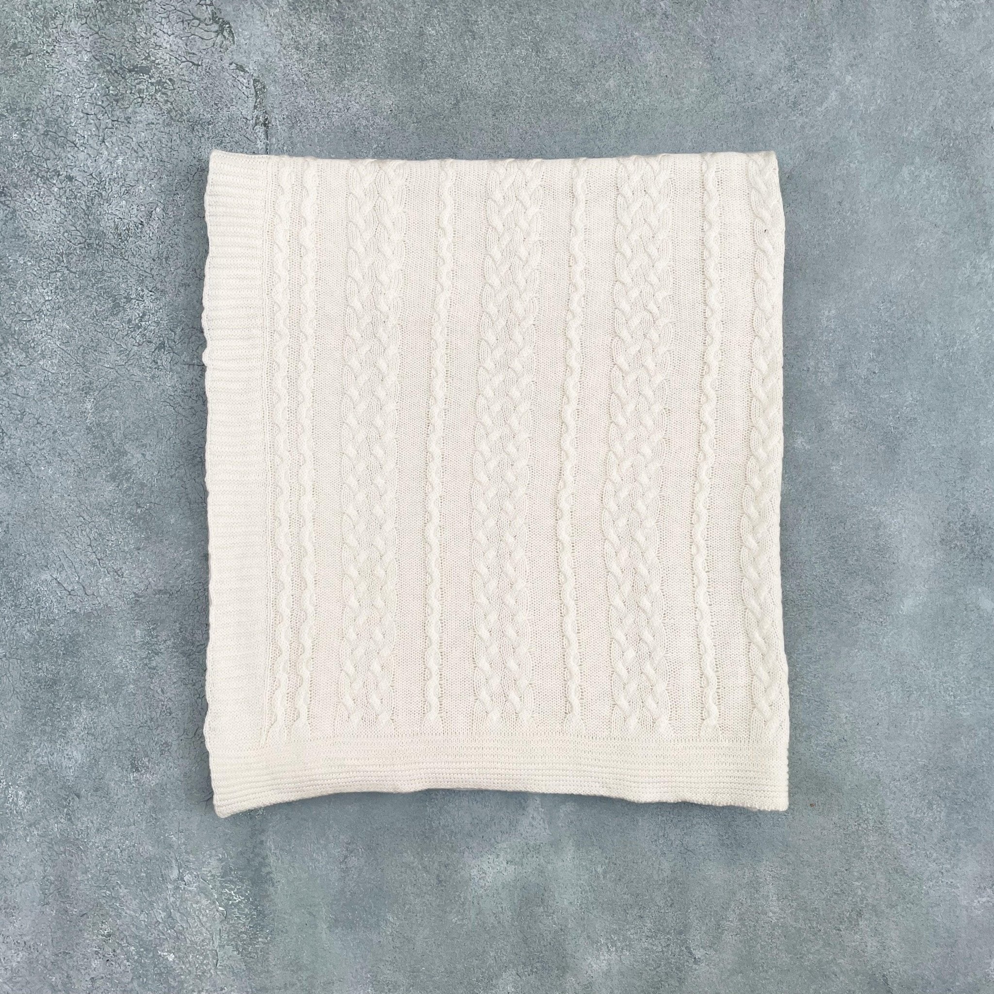 Flat lay of ivory cotton cable knit throw