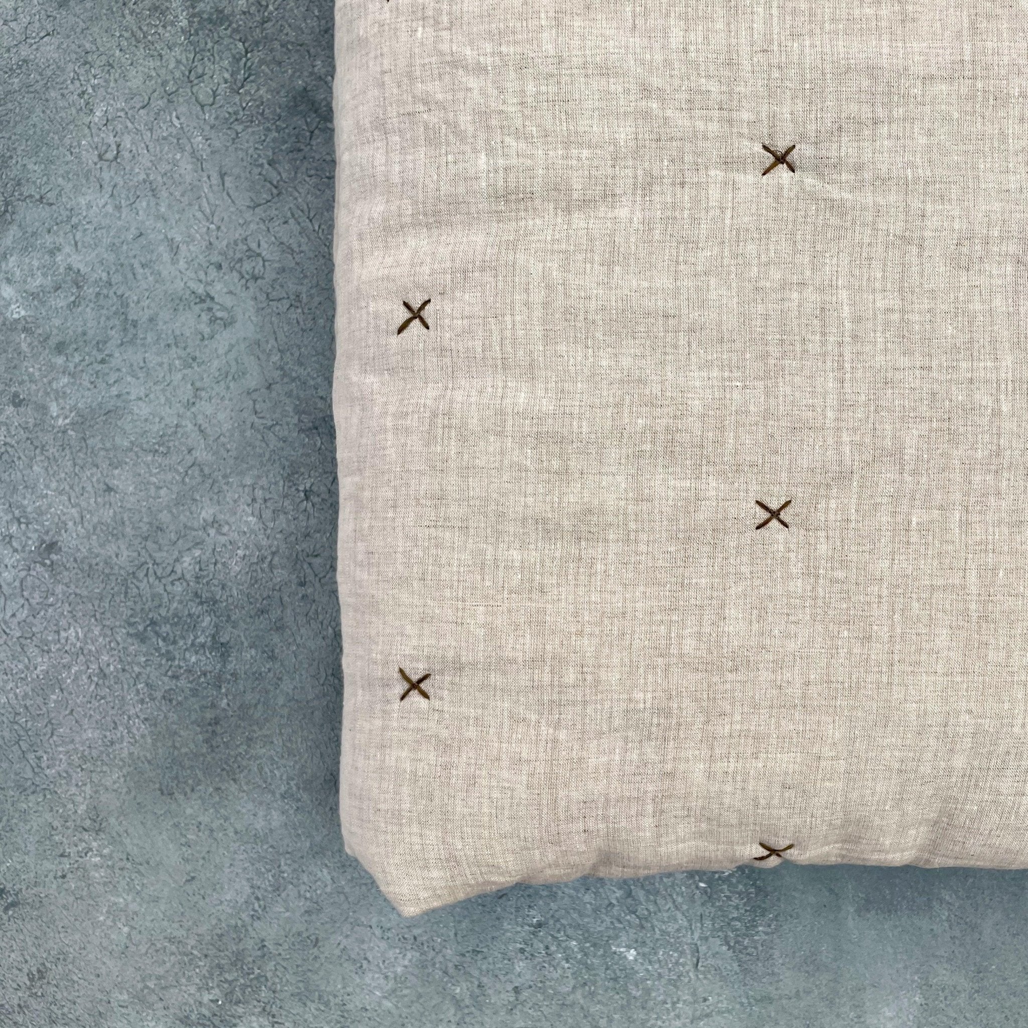 Close-up of natural ivory chambray pure linen quilt with stitched star detail