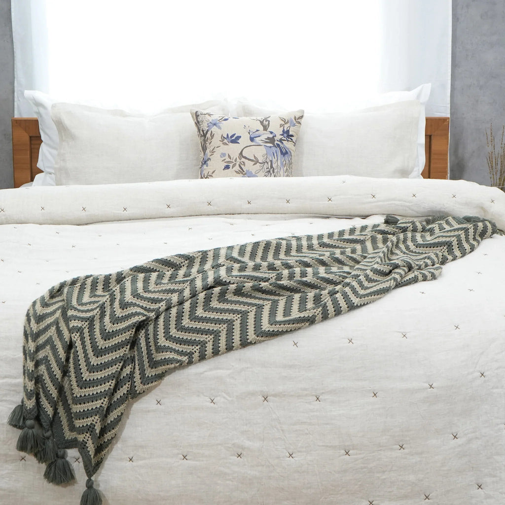 Natural ivory chambray pure linen quilt folded at the foot of a bed