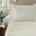 Verona ivory mist 300 thread count cotton sateen sheet set styled on a bed
